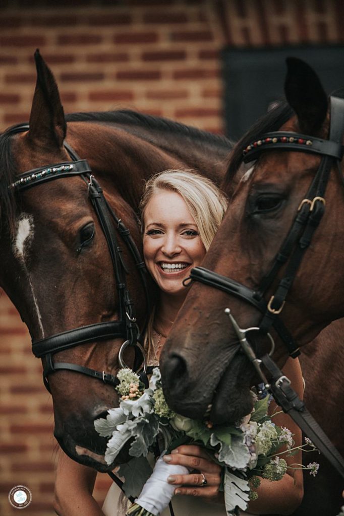 bride laughs and poses with her horse on her wedding day in west grove pa farm wedding