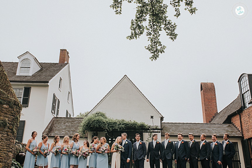 wedding party portrait with soft blue dresses and bright multi colored flowers