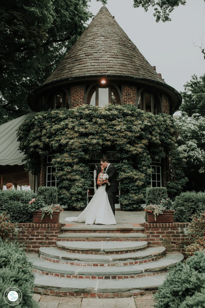 Bride and Groom kiss in front of the historic round room outside at Greenville Country Club in Greenville Delaware
