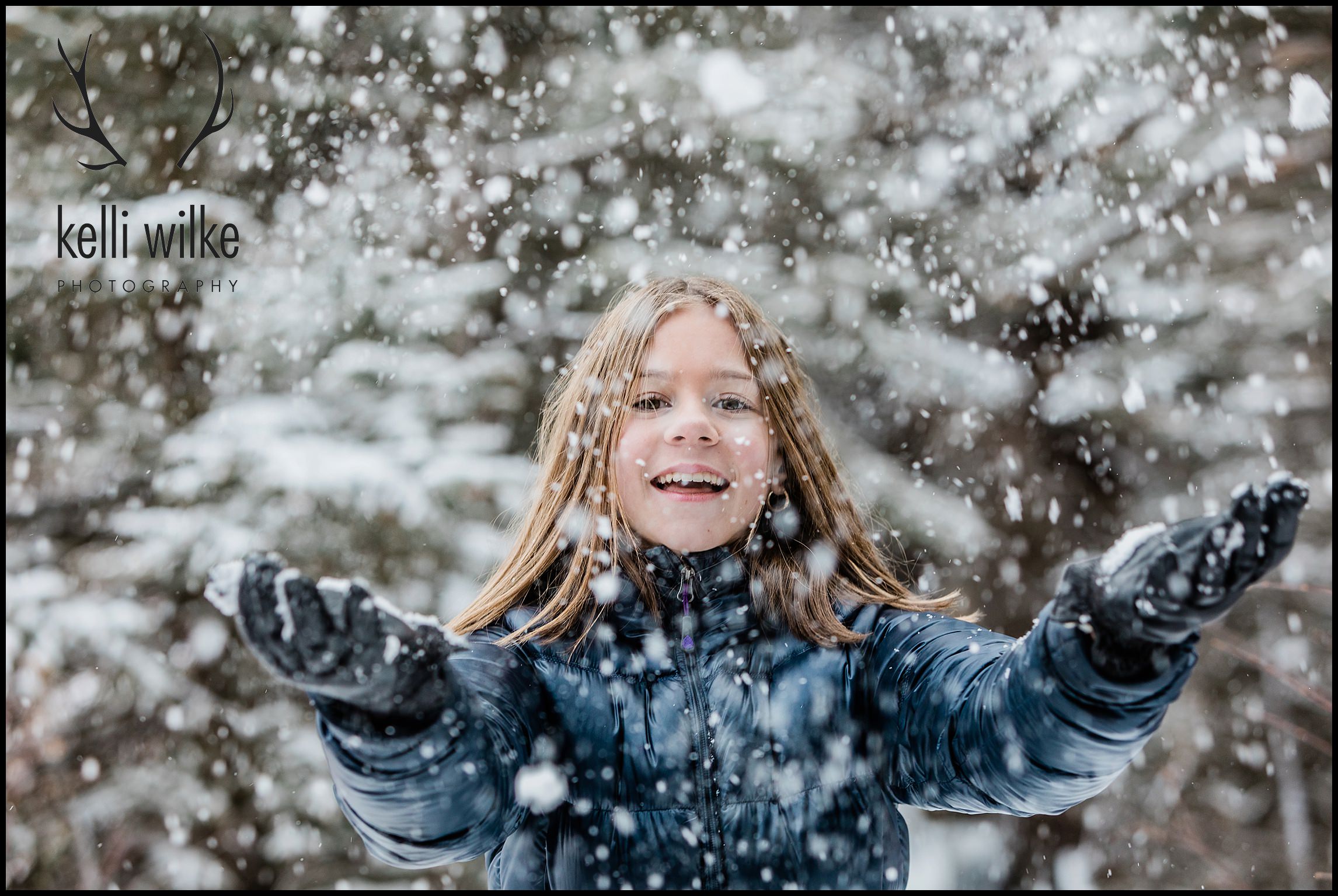 girl throws snow in the air for a family portrait session