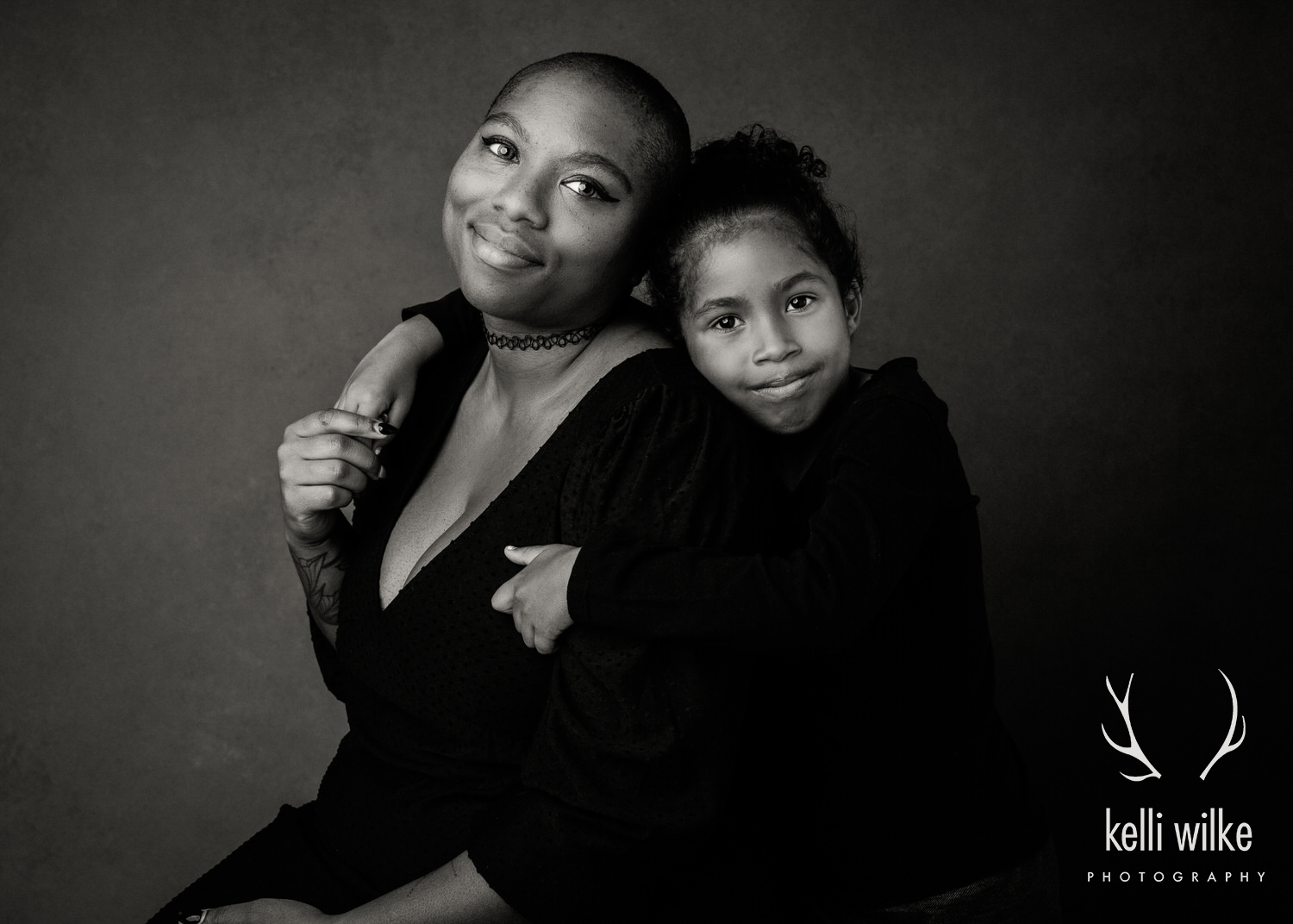 A black and white portrait of a little girl hugging her mom captured by Kelli Wilke Photography in Wilmington, Delaware. 