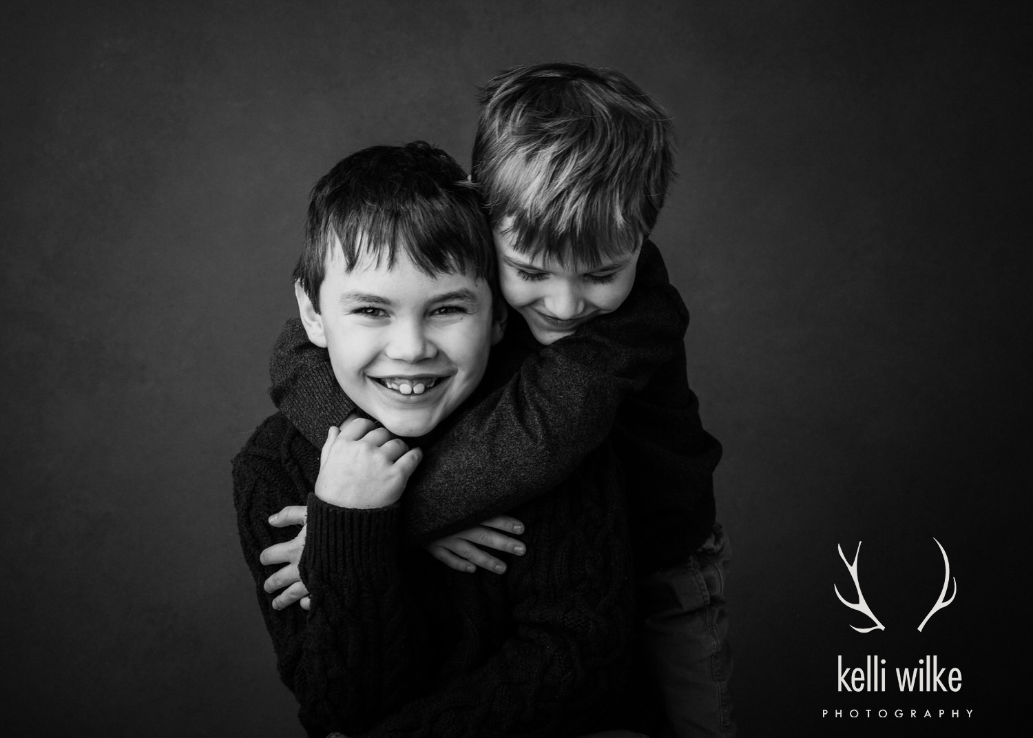 A picture of two little boys, one hugging the other photographed by Kelli Wilke Photography in Wilmington, Delaware. 