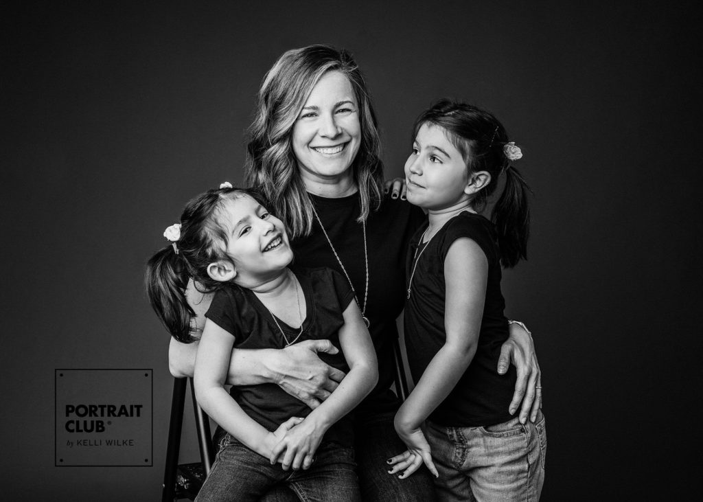 A candid picture of a mom and her two little girls during a family photo session with Portrait Club by Kelli Wilke. 